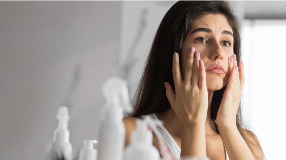 Woman looking at her skin showing signs of stress